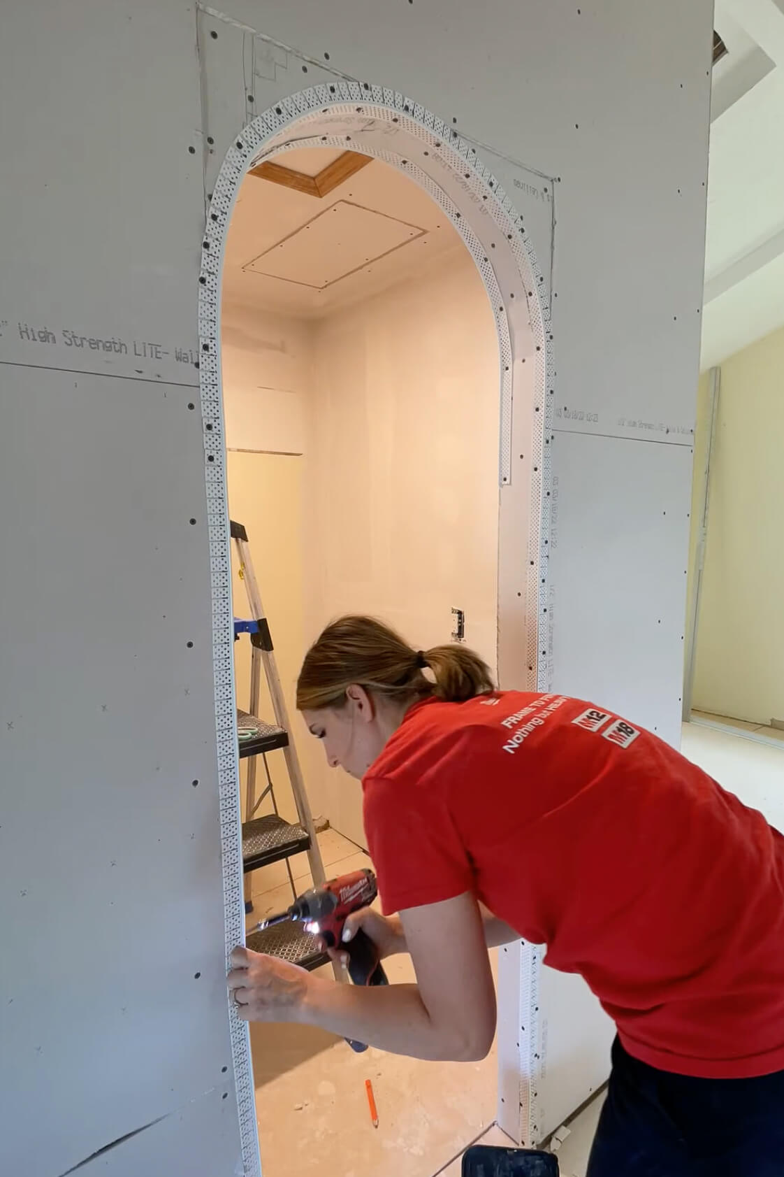 Adding corner bead while drywalling an arched doorway.
